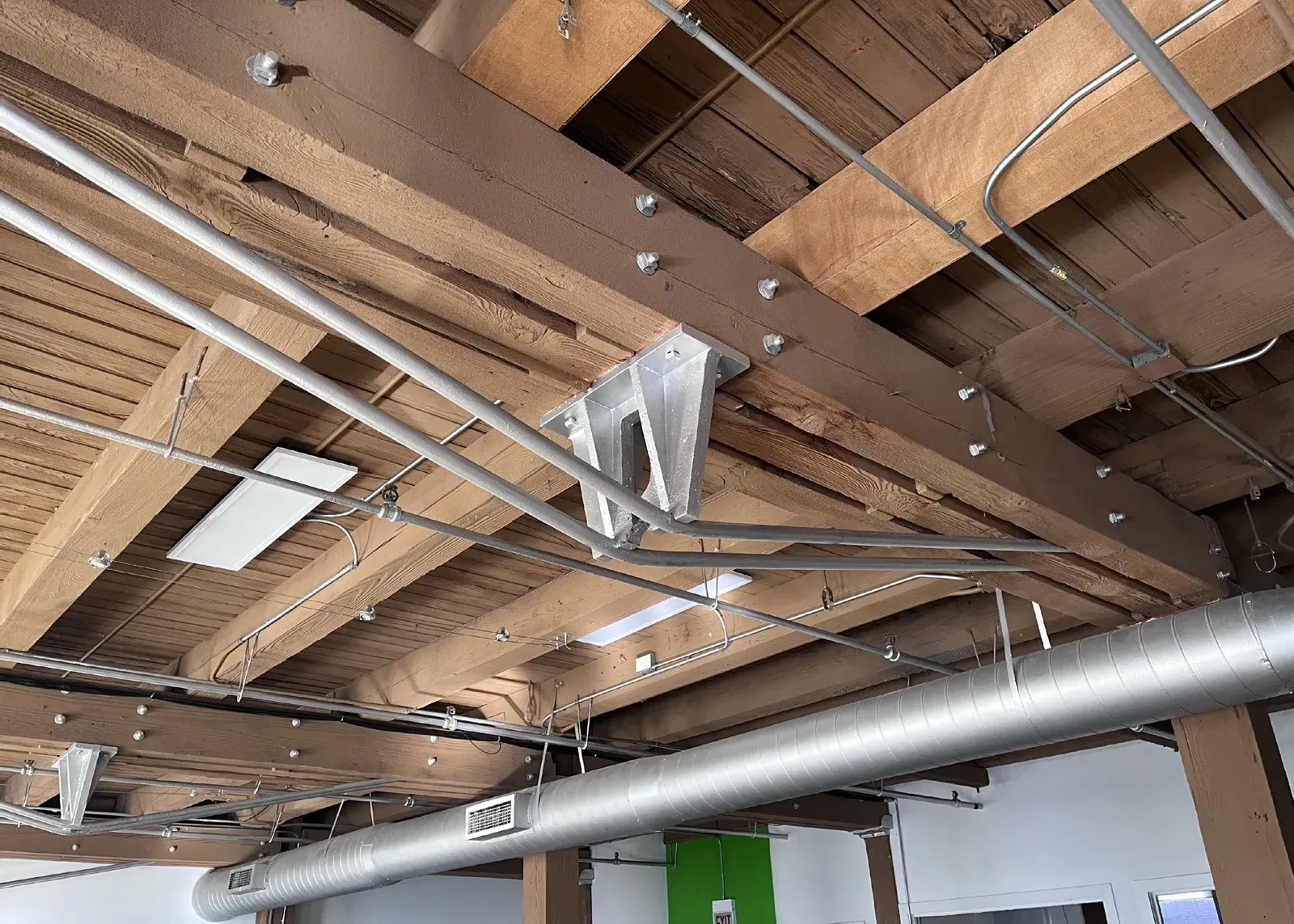 Exposed heavy-timber beams and joists at the ceiling of an upper floor